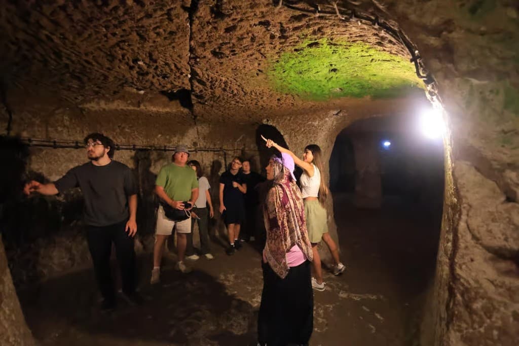 Guests walking a Derinkuyu Underground City tunnel on the bookable Cappadocia Green Tour in Göreme