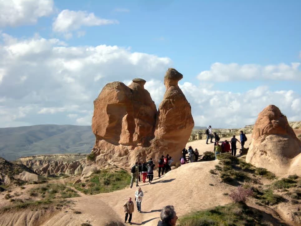 Guests approaching the camel-shaped rock in Devrent Valley on the bookable Cappadocia Red Tour from The Owl Cave Hotel