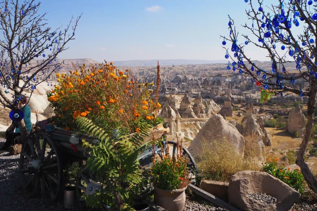 Flower cart and nazar-bead trees overlooking a Göreme valley panorama on the Cappadocia Red Tour from The Owl Cave Hotel