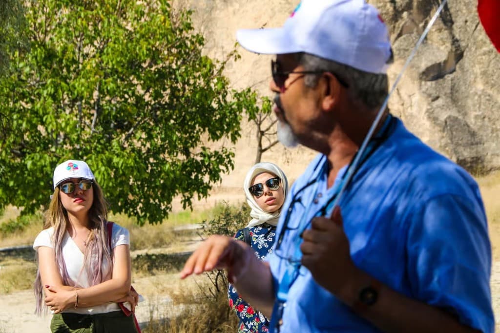 Guide briefing guests among the valleys on the bookable Cappadocia Red Tour from The Owl Cave Hotel, Göreme