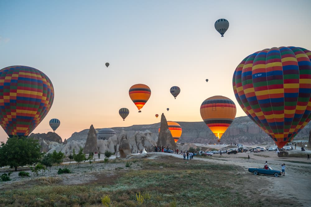 Balloons inflating on a Göreme launch field at dawn for the bookable Göreme Sunrise Balloon Flight from The Owl Cave Hotel