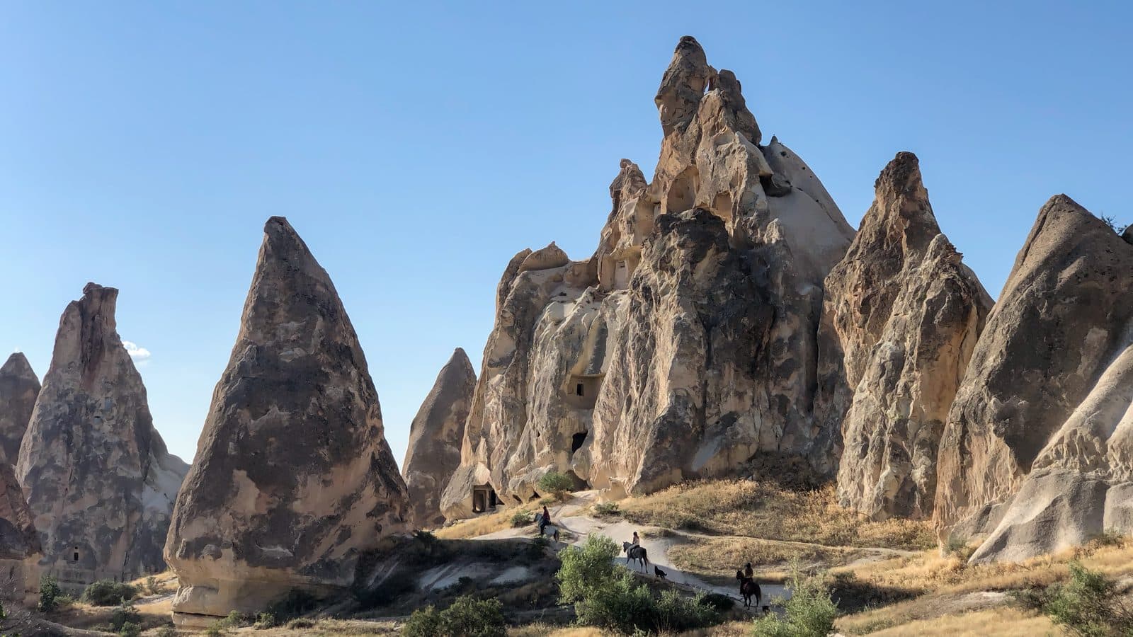 Tall dark fairy chimneys. Fairy Chimney Horse Ride, arranged from The Owl Cave Hotel in Göreme, Cappadocia.