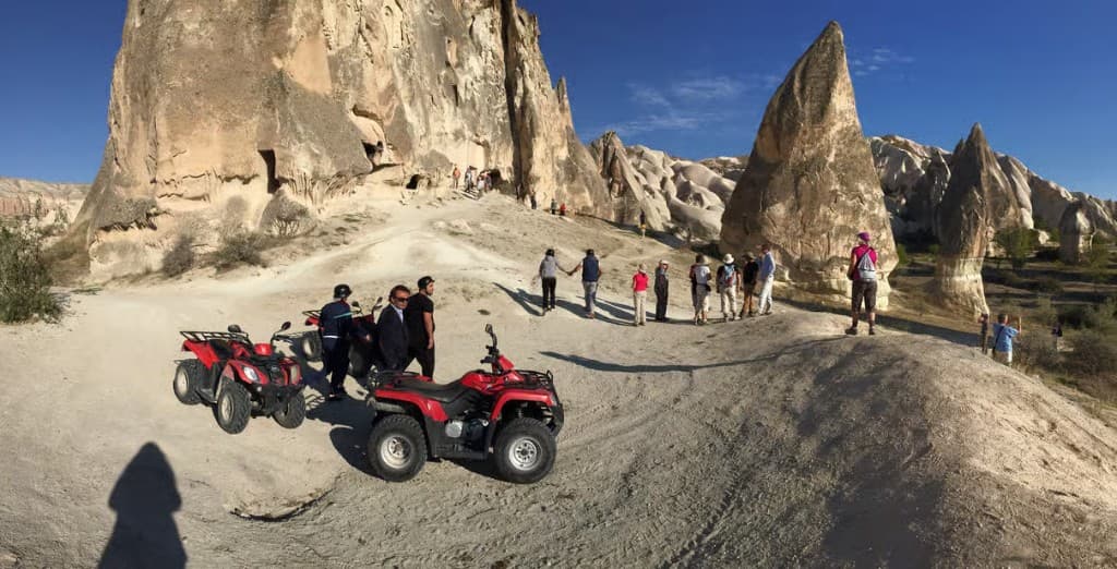 Red quads at a fairy-chimney viewpoint on the bookable Göreme Quad Safari from The Owl Cave Hotel in Göreme