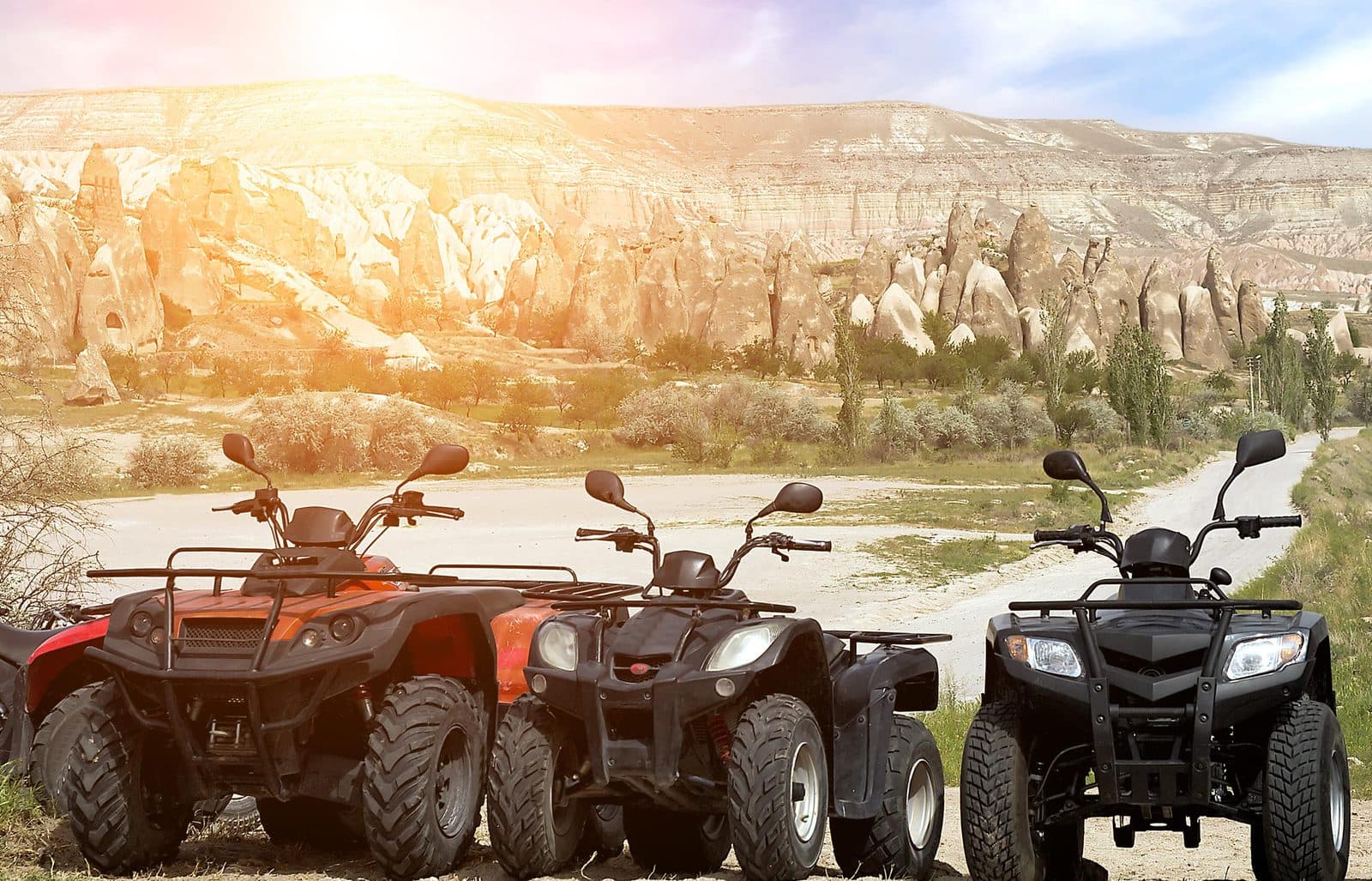 Three ATVs parked facing fairy chimneys at sunset. Sunset ATV Safari, arranged from The Owl Cave Hotel in Göreme, Cappadocia.