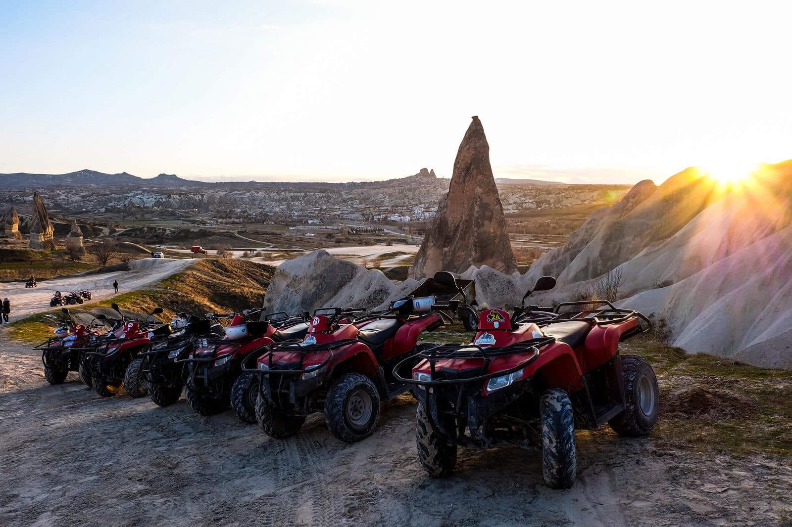 A row of red ATVs on a ridge at sunset. Sunset ATV Safari, arranged from The Owl Cave Hotel in Göreme, Cappadocia.