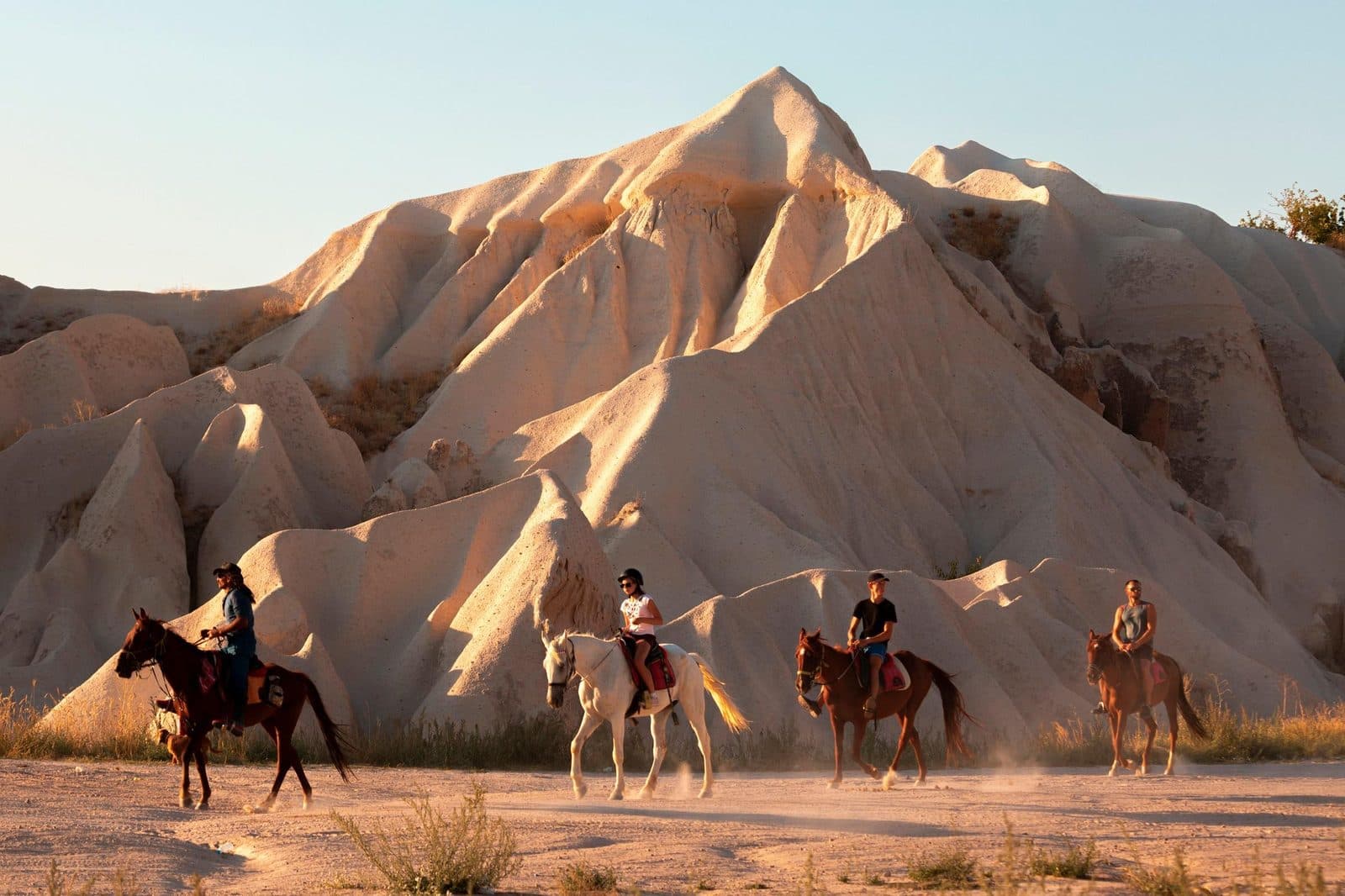 A line of riders in warm light on a track. Sunset Horse Trek, arranged from The Owl Cave Hotel in Göreme, Cappadocia.