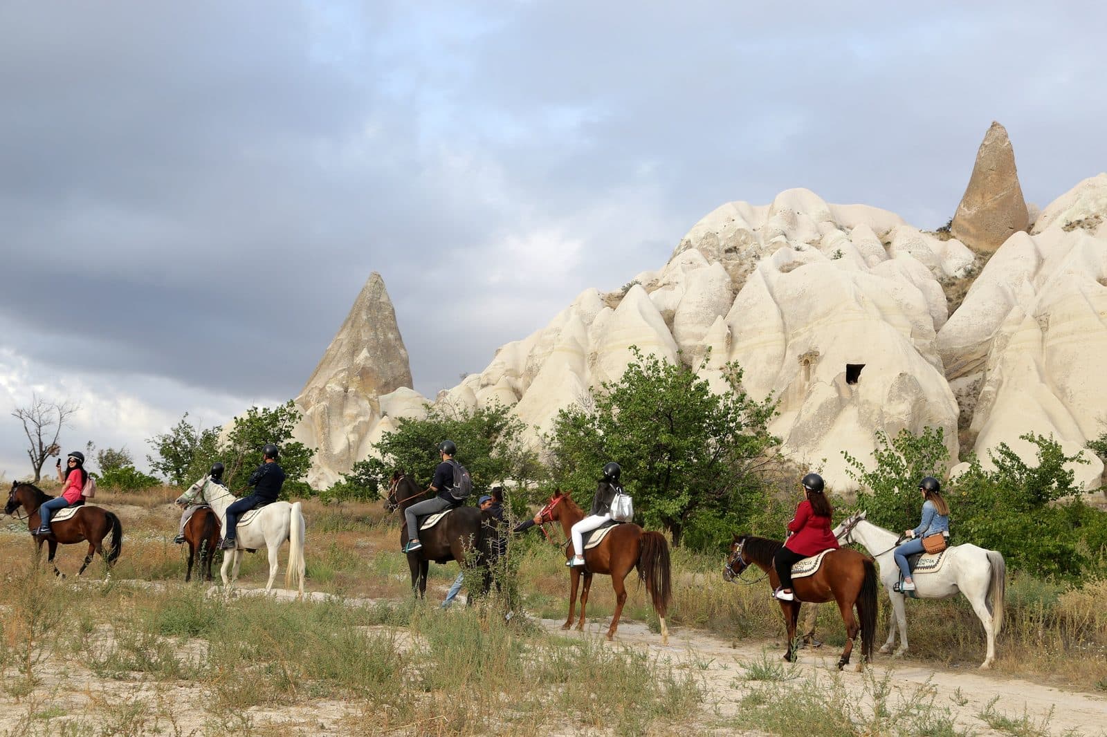 Riders passing white fairy chimneys. Sunset Horse Trek, arranged from The Owl Cave Hotel in Göreme, Cappadocia.
