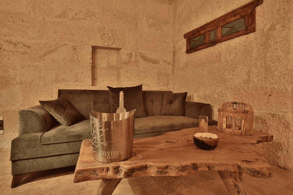 Cave Suite seating area with sofa and minibar table at The Owl Cave Hotel, a bookable cave suite in Göreme