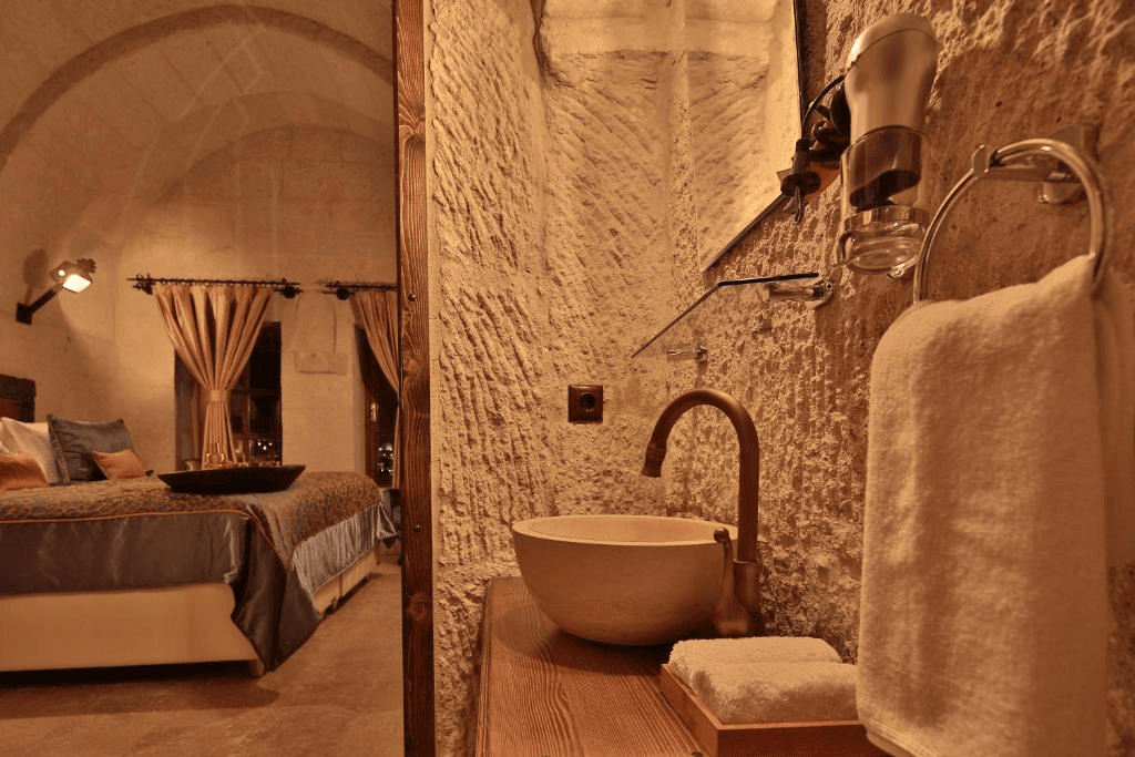 Stone sink looking through to the Deluxe Arch Room with View bedroom at The Owl Cave Hotel in Göreme