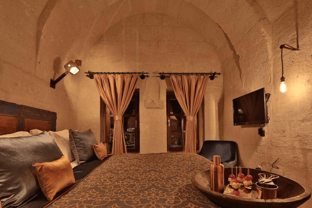 Balcony windows, terrace doors, and flat-screen TV in the Deluxe Arch Room with View at The Owl Cave Hotel, Göreme, Cappadocia