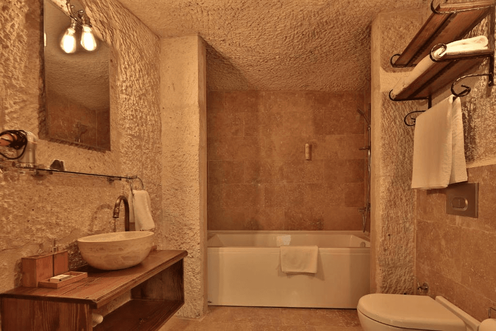 Private bathroom with bath and shower in the Deluxe King Suite at The Owl Cave Hotel, Göreme, Cappadocia