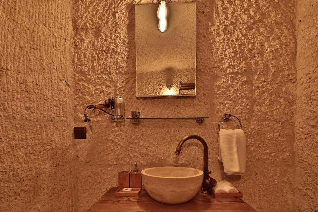 Stone sink in the Deluxe King Suite private bathroom at The Owl Cave Hotel in Göreme
