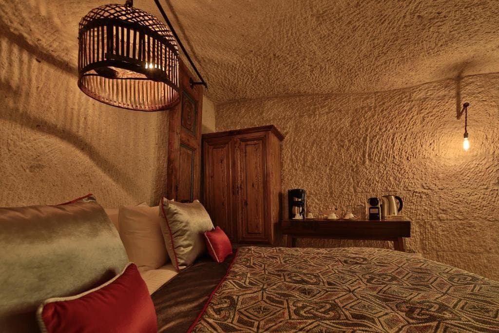 Deluxe King Suite king bed, wardrobe, and coffee station at The Owl Cave Hotel in Göreme