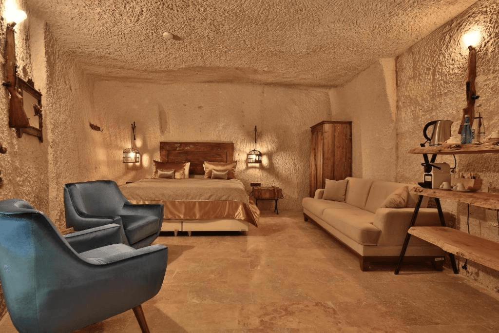 Bookable Family Suite in Göreme showing the living room, sofa, and queen bedroom in a volcanic tuff cave at The Owl Cave Hotel, Cappadocia