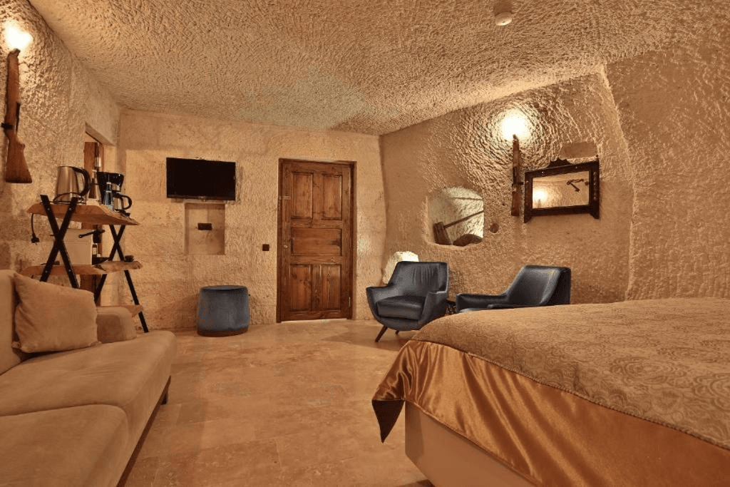 Family Suite living room with sofa, coffee station, and flat-screen TV at The Owl Cave Hotel in Göreme