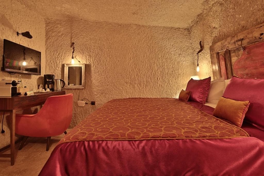 Coffee machine, minibar desk, and flat-screen TV in the bookable Superior Cave Room at The Owl Cave Hotel, Göreme, Cappadocia