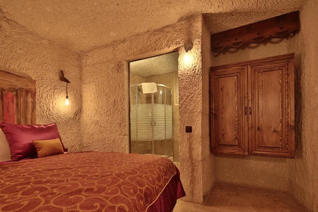Private bathroom and wooden wardrobe in the Superior Cave Room at The Owl Cave Hotel, a bookable cave room in Göreme