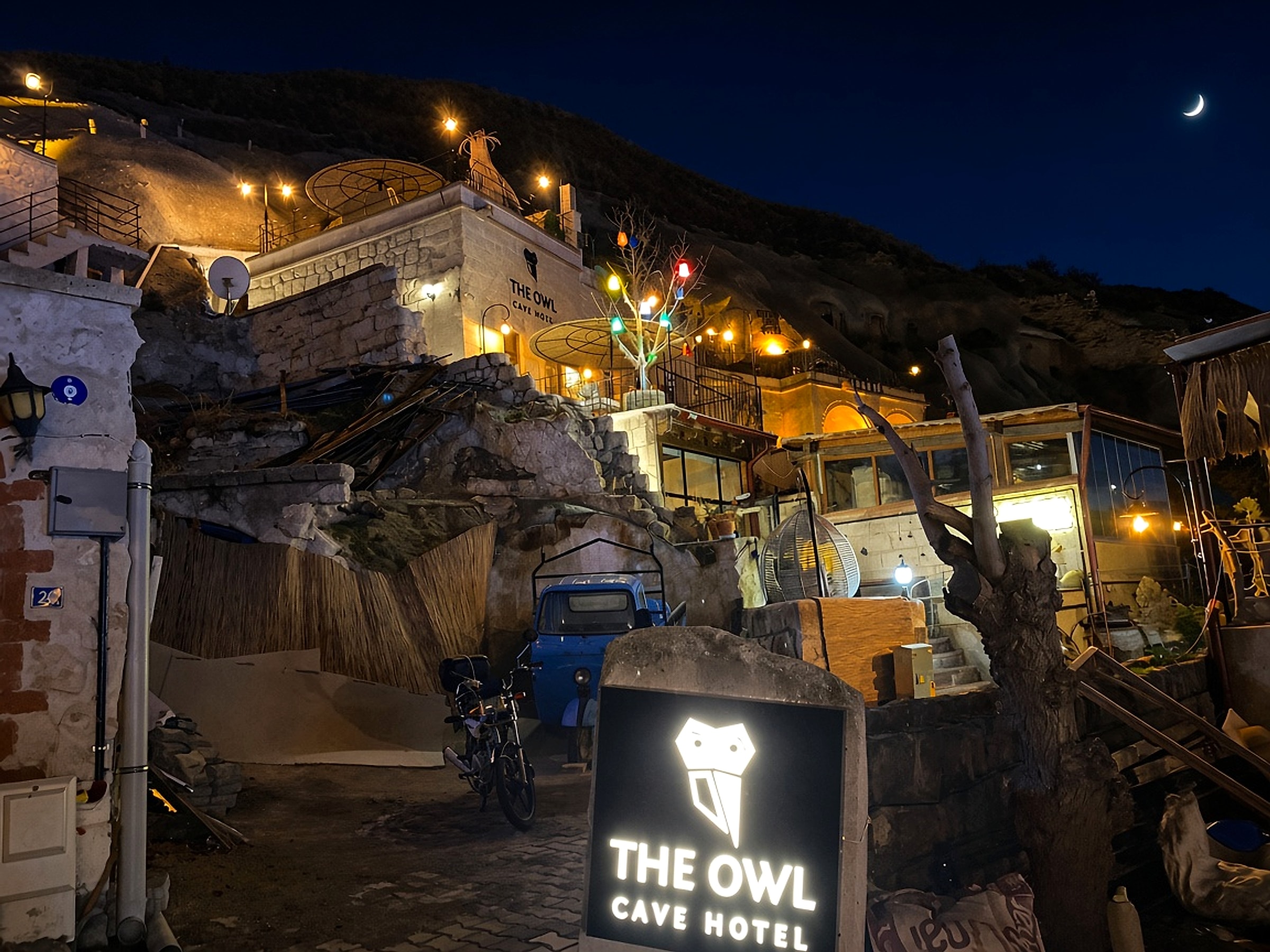 Night entrance to The Owl Cave Hotel in Göreme, Cappadocia, with the hotel sign under the stars