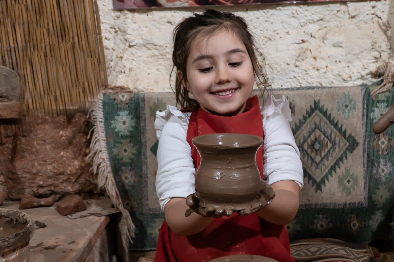 A child holding a clay pot she has made. Avanos Pottery Workshop, arranged from The Owl Cave Hotel in Göreme, Cappadocia.