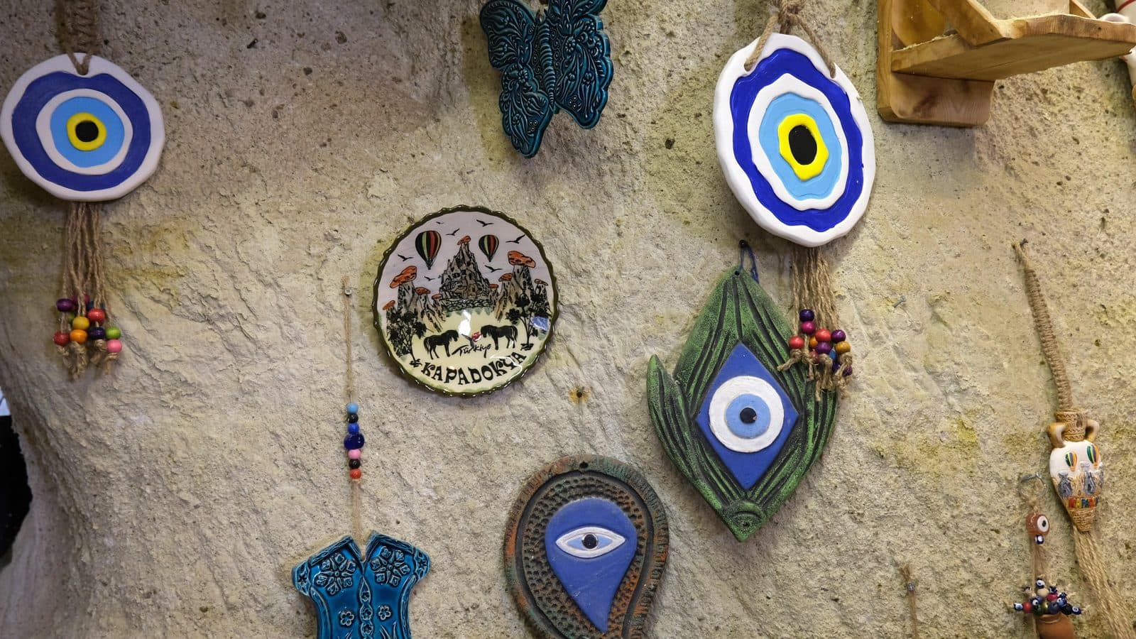 Evil-eye ceramics and painted plates hung on a workshop wall. Avanos Pottery Workshop, arranged from The Owl Cave Hotel in Göreme, Cappadocia.