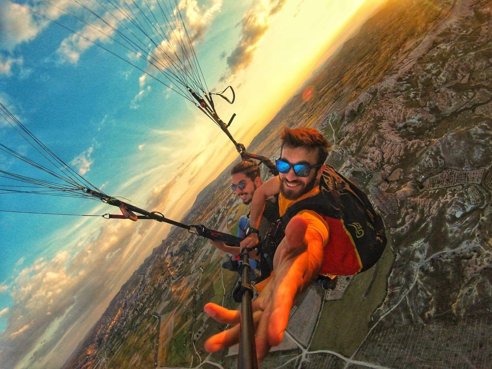 A tandem pair in flight against the sky and the canopy. Tandem Paragliding, arranged from The Owl Cave Hotel in Göreme, Cappadocia.