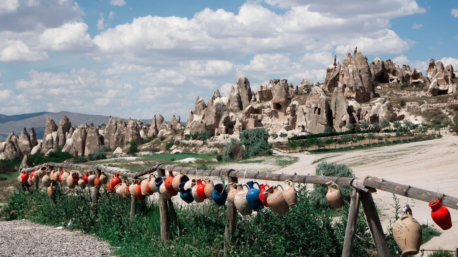 A valley of fairy chimneys with a row of red clay pots in front. Cappadocia Red and Green Day, arranged from The Owl Cave Hotel in Göreme, Cappadocia.