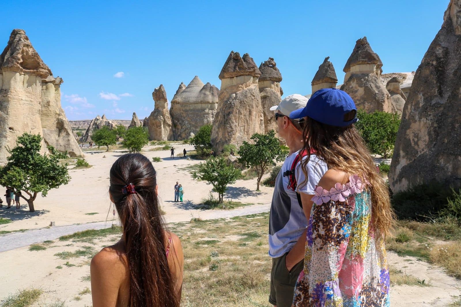Two guests on a sandy path between fairy chimneys. Fairy Chimneys and Wine Tasting, arranged from The Owl Cave Hotel in Göreme, Cappadocia.