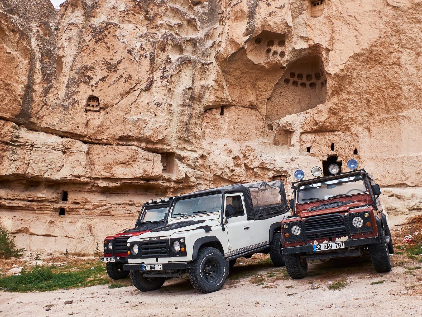 White and black jeeps parked under a rock overhang. Sunrise or Sunset Jeep Safari, arranged from The Owl Cave Hotel in Göreme, Cappadocia.