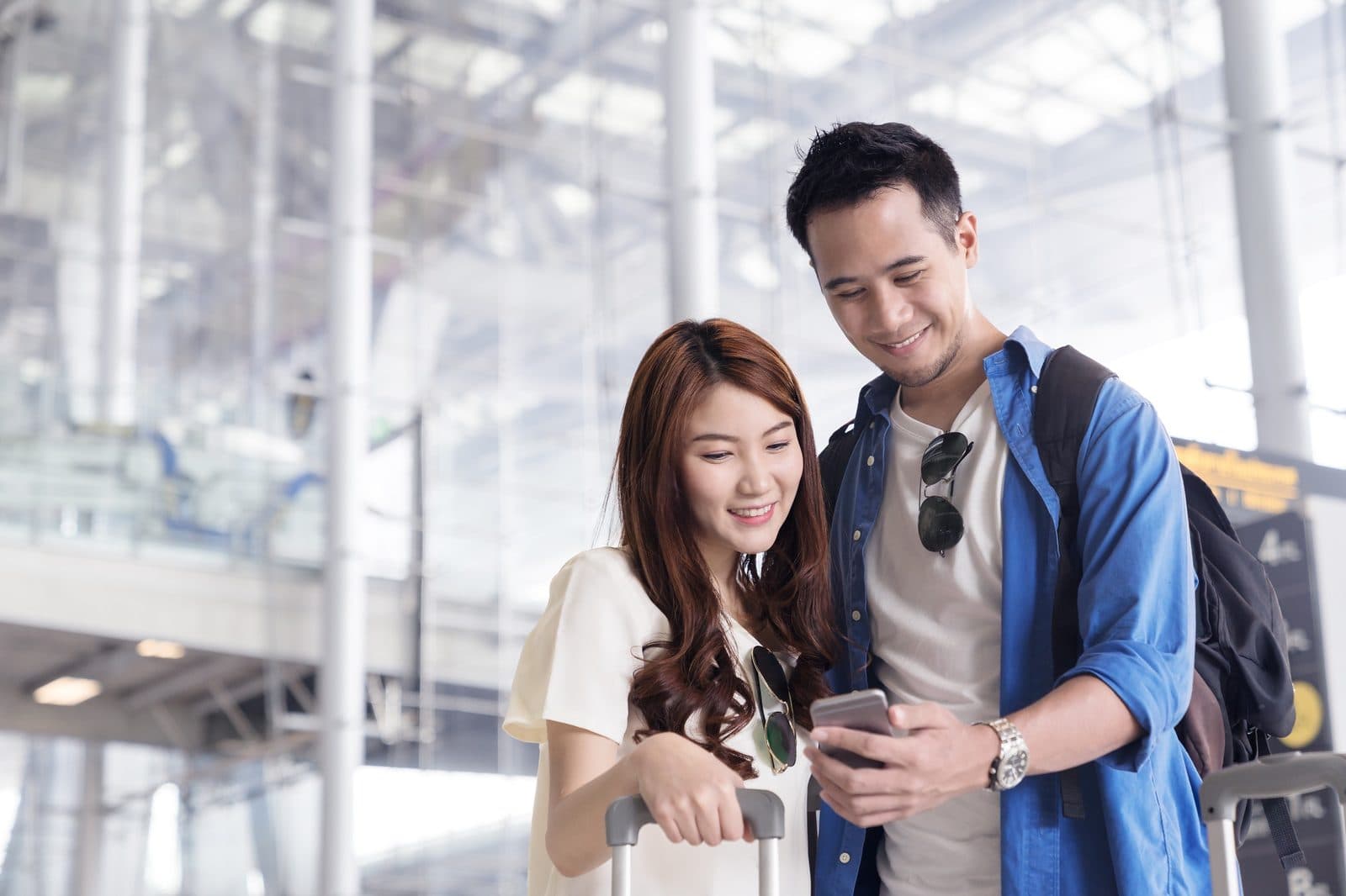 A couple looking at a phone in an airport terminal. Nevşehir Airport Transfer, arranged from The Owl Cave Hotel in Göreme, Cappadocia.