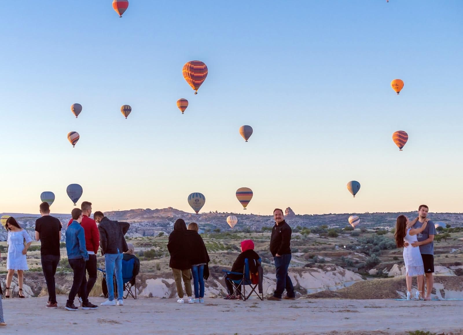 A group watching balloons in low warm light. Sunrise Balloon Watching, arranged from The Owl Cave Hotel in Göreme, Cappadocia.