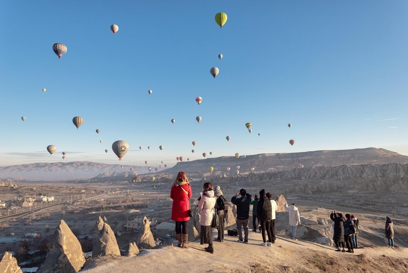 A group on a ridge watching hot air balloons. Sunrise Balloon Watching, arranged from The Owl Cave Hotel in Göreme, Cappadocia.