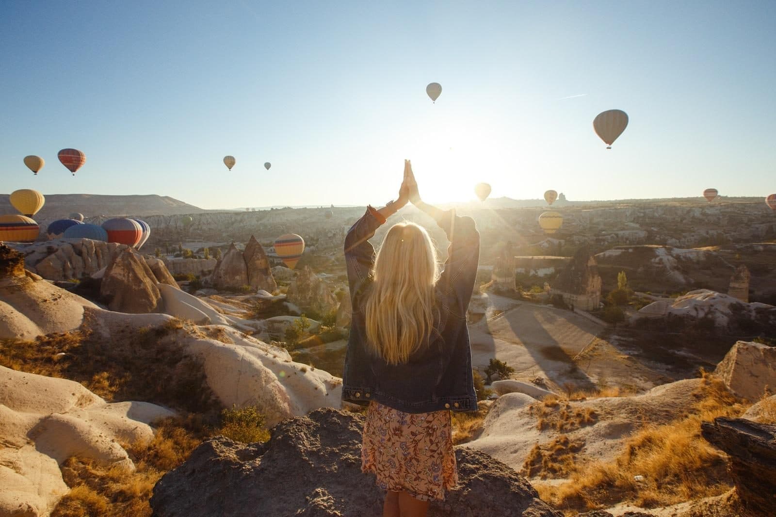 A guest from behind photographing a sky full of balloons. Sunrise Balloon Watching, arranged from The Owl Cave Hotel in Göreme, Cappadocia.