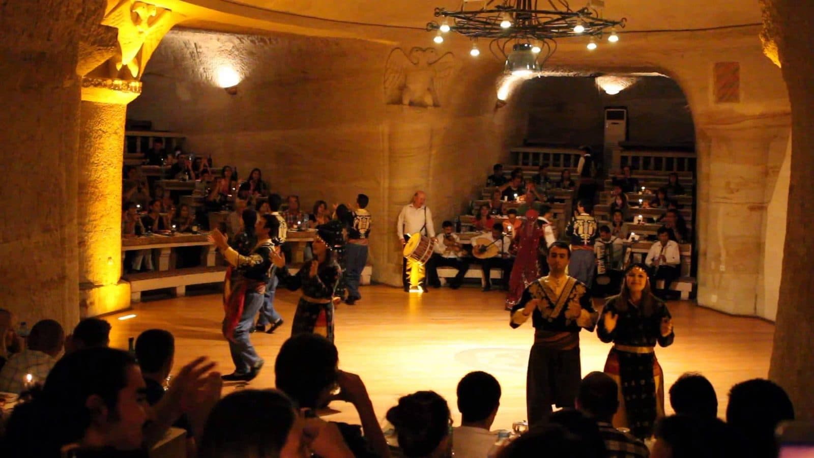 Dancers performing in a wide cave hall. Turkish Night at a Cave Restaurant, arranged from The Owl Cave Hotel in Göreme, Cappadocia.