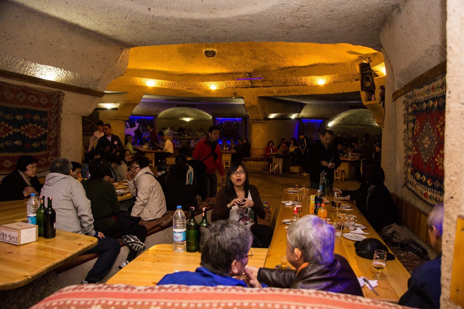 A cave restaurant dining room with a stone fireplace. Turkish Night at a Cave Restaurant, arranged from The Owl Cave Hotel in Göreme, Cappadocia.