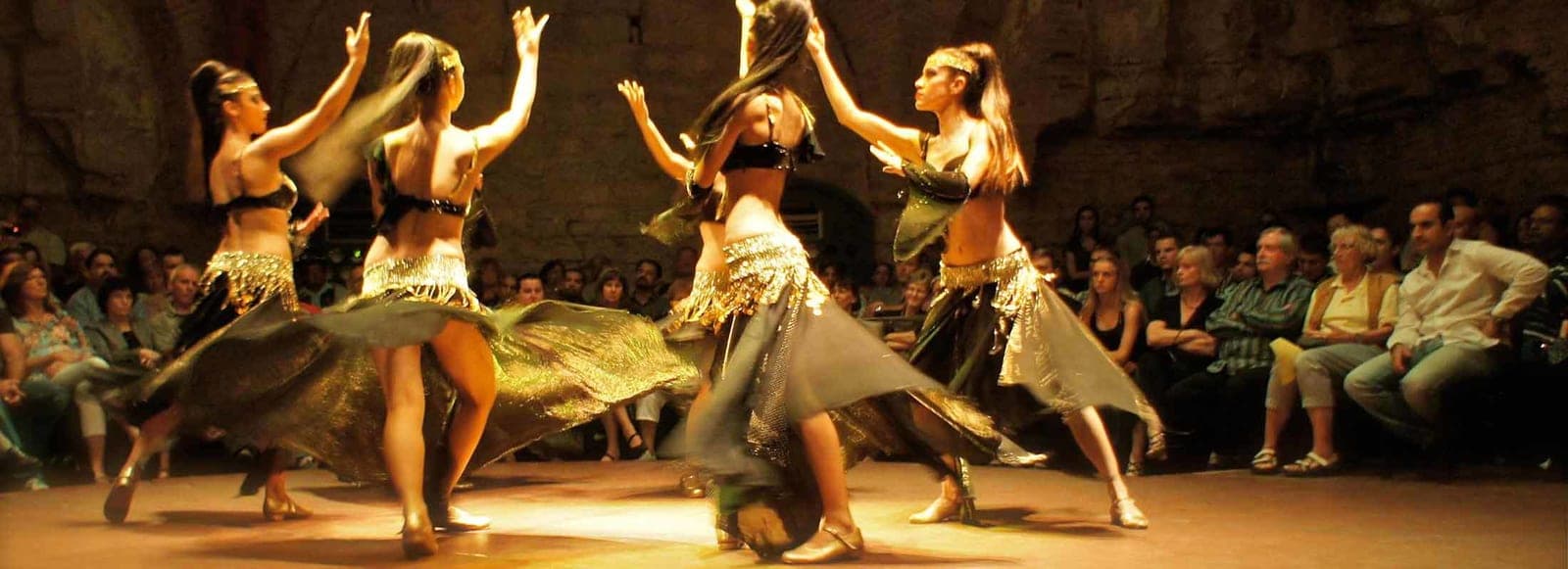 Two dancers on a wooden floor in front of guests. Turkish Night at a Cave Restaurant, arranged from The Owl Cave Hotel in Göreme, Cappadocia.